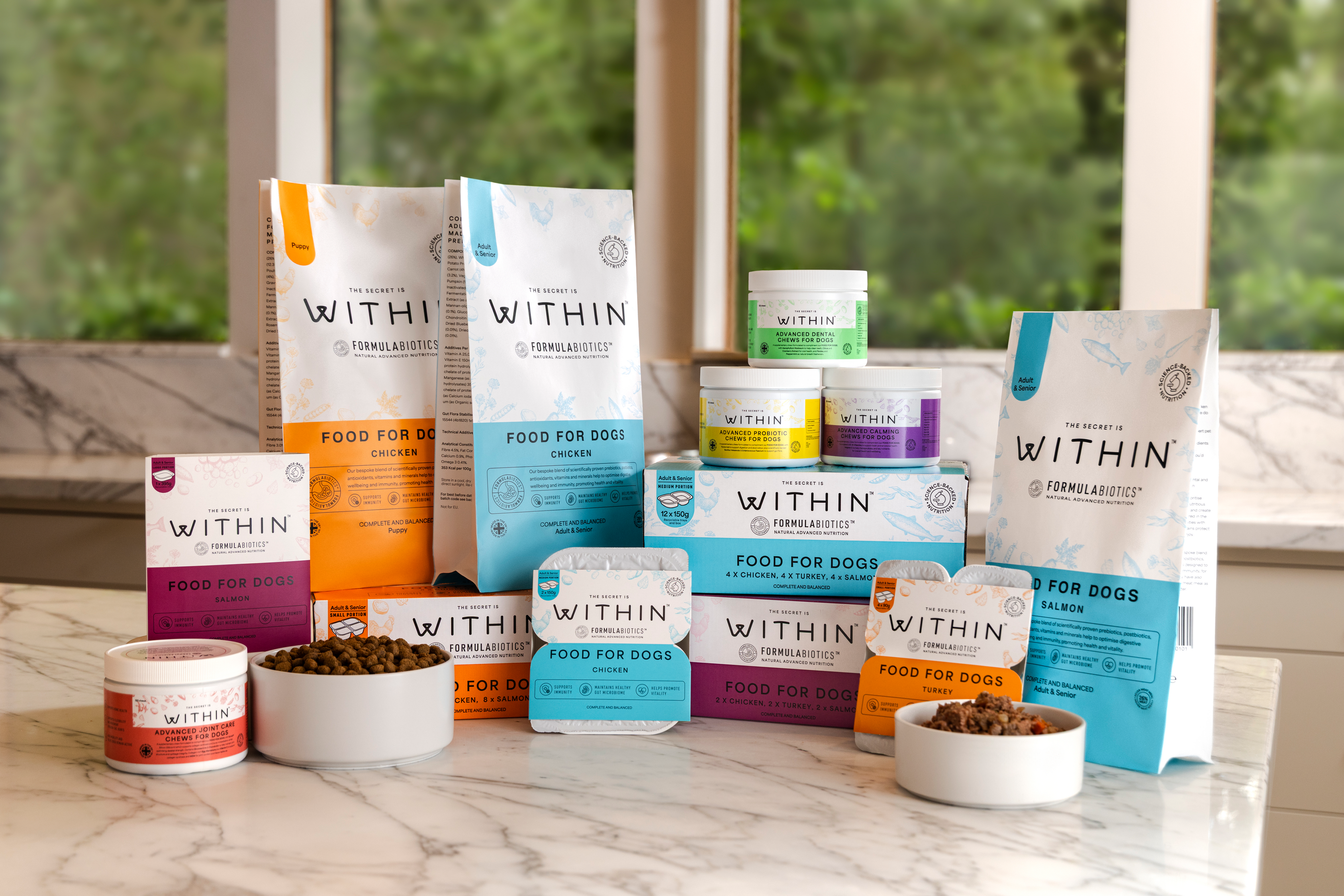 Studio shot of the complete WITHIN range including dry dog food, wet dog food and supplements for dogs.